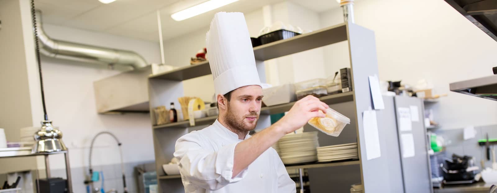 Restaurant chef lifts container of food to verify quantity
